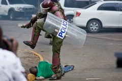 Cảnh sát chống bạo động đánh người. (Nguồn: AP)