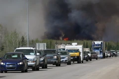 Đoàn xe sơ tán di chuyển tại khu vực đường cao tốc gần đám cháy rừng ở Fort McMurray, Alberta, Canada. (Nguồn: AFP/TTXVN)