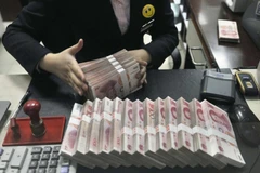 Kiểm đồng Nhân dân tệ tại một điểm giao dịch ngoại hối ở Thượng Hải, Trung Quốc. (Nguồn: Reuter/TTXVN)