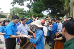 Bí thư Đoàn Thanh niên TTXVN Trần Tiến Duẩn trao quà cho nhân dân vùng lũ xã Hòa Hải. (Ảnh: TTXVN)