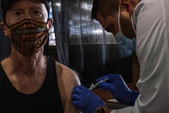 Nhân viên y tế tiêm vaccine phòng cúm cho người dân tại bang Michigan, Mỹ. (Ảnh: AFP/TTXVN)