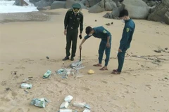 Các cán bộ, chiến sỹ Đồn biên phòng Sa Huỳnh kiểm tra các gói màu trắng nghi là ma túy. (Ảnh: TTXVN)