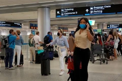 Hành khách đeo khẩu trang phòng lây nhiễm COVID-19 tại sân bay ở Miami, Florida, Mỹ. (Ảnh: AFP/TTXVN)