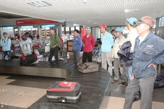 Lao động trở về từ Libya đang nhận hành lý tại sân bay Nội Bài. (Ảnh: Anh Tuấn/TTXVN)