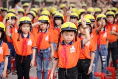 Học sinh trường tiểu học Sơn Lôi A tham gia hướng dẫn đội mũ bảo hiểm đúng cách. (Ảnh: CTV/Vietnam+)