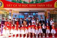 Giáo viên và học sinh tại tỉnh Thái Nguyên nhận mũ bảo hiểm từ dự án Hành trong an toàn. (Ảnh: CTV/Vietnam+)