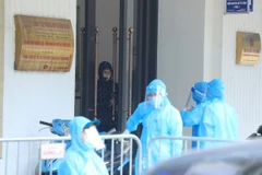 Cơ quan chức năng thực hiện các biện pháp phòng, chống COVID-19 quanh văn phòng làm việc của bệnh nhân 3633. (Ảnh: TTXVN)