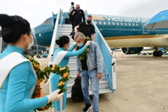 Những hành khách quốc tế trên chuyến bay thí điểm đón du khách quốc tế đến Việt Nam. (Ảnh: CTV/Vietnam+)