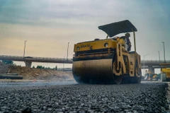 Đơn vị nhà thầu thi công thảm bê tộng nhựa. (Ảnh: Minh Hiếu/Vietnam+)