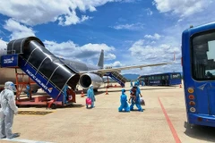 Hành khách Quảng Nam xuống sân bay Đà Nẵng và được bố trí đưa về cách ly tập trung, bảo đảm quy trình khép kín phòng chống dịch. (Ảnh: CTV/Vietnam+)