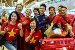 Cổ động viên Việt Nam chụp ảnh với cầu thủ Quang Hải. (Ảnh: CTV/Vietnam+)