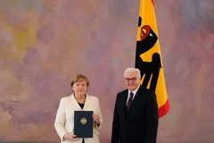Bà Angela Merkel (trái) nhận quyết định bổ nhiệm từ Tổng thống Đức Frank-Walter Steinmeier sau khi tái đắc cử Thủ tướng Đức, tại Berlin ngày 14/3. (Nguồn: AFP/ TTXVN)