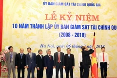 Thủ tướng Nguyễn Xuân Phúc trao tặng Huân chương lao động hạng Ba cho Uỷ ban giám sát Tài chính Quốc gia. (Ảnh: Thống Nhất/TTXVN)