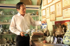 Thầy giáo Võ Thanh Phương với những cổ vật sưu tầm được. (Ảnh: Phước Ngọc/TTXVN)