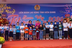 Lãnh đạo Liên đoàn Lao động tỉnh Kiên Giang và Thành ủy Rạch Giá tặng quà Tết cho học sinh là con đoàn viên có hoàn cảnh khó khăn, học giỏi. (Ảnh: Văn Sĩ/TTXVN)
