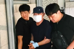 Nghi phạm (giữa) gây ra vụ nổ tại bệnh viện ở Gwangju bị cảnh sát bắt giữ. (Nguồn: Korea Joongang Daily)
