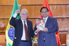 Ông Pedro de Oliveira, Tổng Thư ký Hội Hữu nghị Brazil-Việt Nam tặng Thủ tướng Phạm Minh Chính cuốn sách Hồ Chí Minh cuộc đời và sự nghiệp vị lãnh tụ giải phóng dân tộc Việt Nam. (Ảnh: Dương Giang/TTXVN)