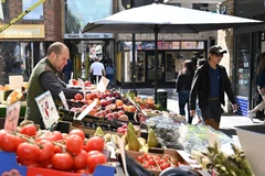 Người dân mua sắm tại một chợ ở London (Anh). (Ảnh: AFP/TTXVN)