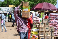 Người dân chuyển lương thực tại khu chợ ở Niamey (Niger). (Ảnh: AFP/TTXVN)