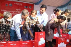 Đại sứ Việt Nam tại Campuchia Nguyễn Huy Tăng trao tặng quà cho người dân tham gia chương trình. (Ảnh: Huỳnh Thảo/TTXVN)