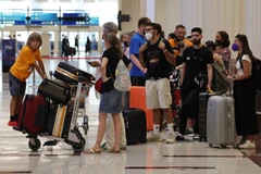 Hành khách tại Sân bay Quốc tế Dubai (UAE). (Ảnh: AFP/TTXVN)