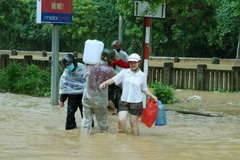 Người dân Lào Cai vượt lũ để có được nước từ khe núi mang về gia đình sử dụng. (Ảnh: Quốc Khánh/TTXVN)