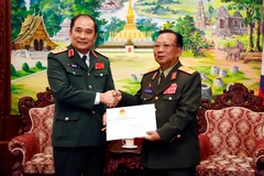 Thượng tướng Phùng Sĩ Tấn, Phó Tổng Tham mưu Trưởng Quân đội Nhân dân Việt Nam chuyển Thư Chúc mừng của Bộ trưởng Quốc phòng Phan Văn Giang tới Bộ trưởng Quốc phòng Lào Chansamone Chanyalath nhân dịp kỷ niệm 75 năm ngày thành lập Quân đội Nhân dân Lào. (Ảnh: Phạm Kiên/TTXVN)
