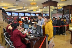 Khách hàng đang giao dịch vàng miếng tại Bảo Tín Minh Châu. (Ảnh: Đức Duy/Vietnam+)