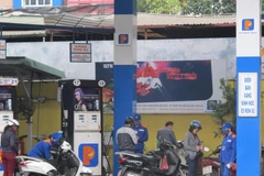 Nhân viên Petrolimex đang bán xăng cho khách hàng. (Ảnh: Đức Duy/Vietnam+)