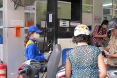 Nhân viên Petrolimex đang bán xăng cho khách hàng. (Ảnh: Đức Duy/Vietnam+)