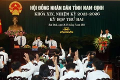 Các đại biểu HĐND tỉnh Nam Định biểu quyết thông qua các Nghị quyết về phát triển kinh tế - xã hội tại kỳ họp thứ 2, HĐND tỉnh Nam Định khóa XIX, nhiệm kỳ 2021-2026. (Ảnh: Văn Đạt/TTXVN)