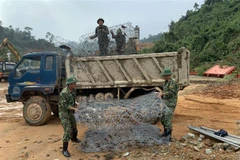 Cán bộ, chiến sỹ Bộ chỉ huy Quân sự tỉnh Thừa Thiên-Huế chuẩn bị rọ đá để sẵn sàng nắn dòng suối Rào Trăng tìm kiếm nạn nhân. (Ảnh: TTXVN phát)