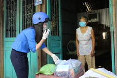 Đội hình Shipper áo xanh phường 11, thành phố Cao Lãnh, tỉnh Đồng Tháp mang nhu yếu phẩm cho hộ nghèo Đặng Thị Bé Tư. (Ảnh: Chương Đài/TTXVN)