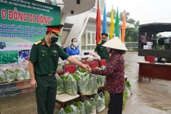 Đại diện Sư đoàn 302 trao sản phẩm từ “Siêu thị 0 đồng di động” cho người dân xã Châu Pha. (Ảnh: Huỳnh Ngọc Sơn/TTXVN)