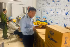 Lực lượng chức năng kiểm tra mật ong có dấu hiệu hàng giả. (Ảnh: PV/Vietnam+)