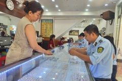 Lực lượng chức năng kiểm tra tại một cơ sở kinh doanh vàng trên địa bàn tỉnh An Giang. (Ảnh: PV/Vietnam+)