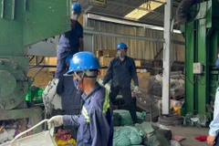 Lực lượng Quản lý Thị trường giám sát tiêu hủy hàng vi phạm. (Ảnh: PV/Vietnam+)