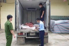 Lực lượng chức năng kiểm tra xe ôtô chở xương và lòng lợn không rõ nguồn gốc. (Ảnh: PV/Vietnam+)