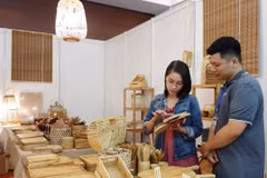 Khách mua sắm sản phẩm thủ công mỹ nghệ tại Hội chợ triển lãm. (Ảnh: TTXVN)