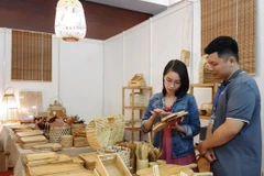 Khách mua sắm sản phẩm thủ công mỹ nghệ tại Hội chợ triển lãm. (Ảnh: TTXVN)