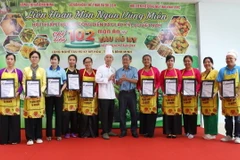 Trao giấy chứng nhận cho các đơn vị tham gia hội thi và công diễn xác lập kỷ lục Việt Nam chế biến 102 món ăn từ tàu hũ ky và dùng kèm tàu hũ ky. (Ảnh: Lê Thúy Hằng/TTXVN)