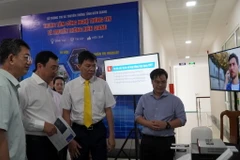 Phó Chủ tịch UBND tỉnh Kiên Giang Nguyễn Lưu Trung (thứ 3 từ trái qua) tham quan gian hàng trưng bày giới thiệu các mô hình, sản phẩm, giải pháp công nghệ. (Ảnh: Văn Sĩ/TTXVN)