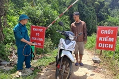 Triển khai phun hóa chất vệ sinh sát khuẩn các phương tiện ra, vào khu vực có ổ dịch. (Ảnh: Đức Thọ/TTXVN)