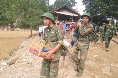 Lực lượng bộ đội khẩn trương cứu trợ cho bà con vùng lũ bản Sa Ná, xã Na Mèo, huyện Quan Sơn, Thanh Hóa. (Ảnh: TTXVN)