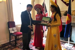 Thứ Trưởng Bộ Ngoại Giao, Chủ nhiệm Ủy ban người Việt Nam ở Nước Ngoài Nguyễn Quốc Cường tặng sách tiếng Việt cho các cháu Việt kiều tại Anh. (Ảnh: Diễm Quỳnh/Vietnam+)