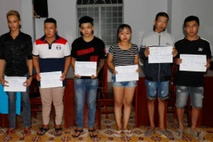 Một số thanh niên trong nhóm tụ tập đua xe, cổ vũ đua xe trái phép bị tạm giữ. (Ảnh: TTXVN phát)