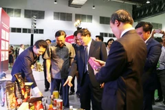 Lãnh đạo Bộ Công thương hai nước và các đại biểu tham quan một số sản phẩm tại hội chợ. (Ảnh: Xuân Tú/TTXVN)