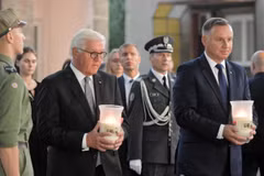 Tổng thống Đức Frank-Walter Steinmeier (trái) và Tổng thống Ba Lan Andrzej Duda (phải) thắp nến tưởng nhớ các nạn nhân. (Ảnh: PAP/TTXVN)