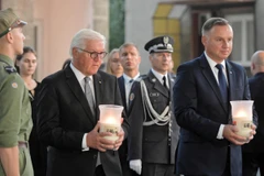 Tổng thống Đức Frank-Walter Steinmeier (trái) và Tổng thống Ba Lan Andrzej Duda (phải) thắp nến tưởng nhớ các nạn nhân. (Ảnh: PAP/TTXVN)