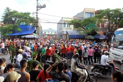 Công nhân tràn xuống lòng đường, gây ùn tắc giao thông kéo dài tại khu vực gần công ty. (Ảnh: An Đăng/TTXVN)